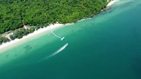 Aerial top down view of small boat arriving at tropical island 4k Stock Footage 276533251