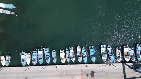 Aerial top down view of small fishing boats moored at the pier in harbor Stockbeeldmateriaal 336955059