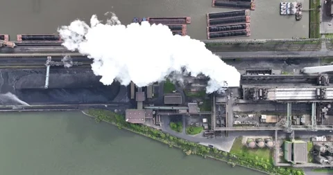 Aerial top-down view of smoke and vapor coming out of a cooling tower at a Stock Footage 275544444