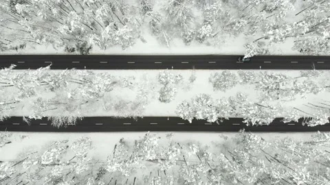 Aerial top-down view of snowed up divided highway on cloudy winter day 스톡 동영상 166691638