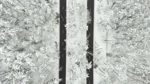 Aerial top-down view of snowed up divided highway on cloudy winter day 스톡 동영상 197775842