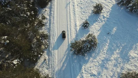 Aerial top down view of the snowy road with black car moving. Shot from drone Stockbeeldmateriaal 197363601