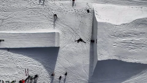 Aerial top down view of snowy ramp, skiers jump and perform tricks, Czechia Stock Footage 266960550