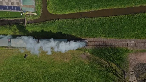 Aerial top down view of steam train running through green dutch countryside Stock Footage 341523954