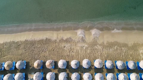 Aerial top down view of straw umbrellas on sandy beach with calm sea waves 스톡 동영상 333148556