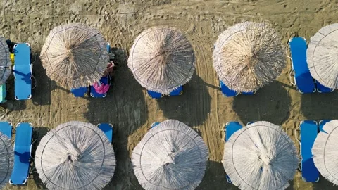 Aerial top down view of straw sun umbrellas on a sandy beach 스톡 동영상 333148721