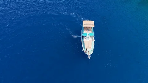 Aerial Top Down View of a Tour Boat Sailing on the Open Blue Sea Stock Footage 317202609