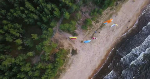 Aerial top down view of tourists enjoying parasailing on sandy beach with Stockbeeldmateriaal 146176815