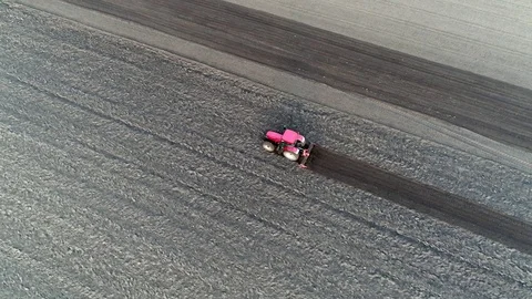 Aerial top down view of tractor plowing dark brown soil 4k Stock Footage 75423098