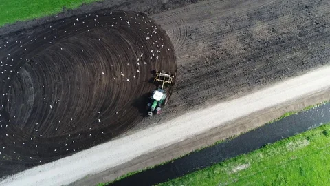 Aerial top down view of tractor plowing the dark soil 4k Stock Footage 78997139