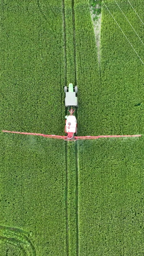 Aerial Top Down View Of Tractor Spraying Pesticides On Green Field Video stock 328939556