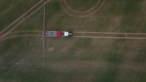 Aerial top down view of tractor towing liquid sprayer in field Stock Footage 337582793