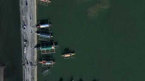 Aerial top down view of traditional Filipino fishing boats along coastal pier Video stock 337409786