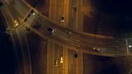 Aerial - Top Down View Of Traffic Crossing The Bridge Over Highway At Night Stock Footage