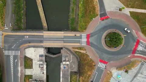 Aerial top down view of traffic and Cars driving on 4 way roundabout next to a Stock Footage 256025126