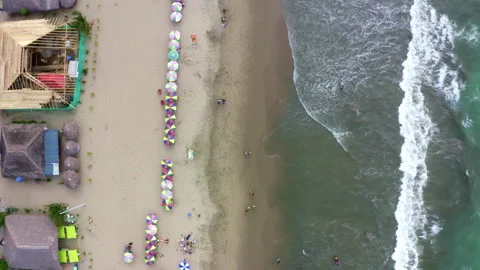 Aerial top down view of a tropical beach ful of colorful parasols and people Stock Footage 169905931