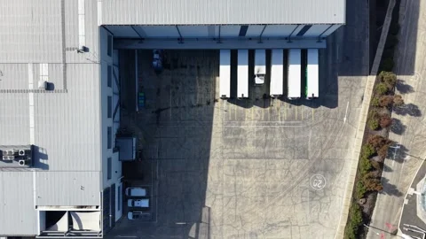 Aerial top down view of trucks at a warehouse loading dock Stock Footage 341918353