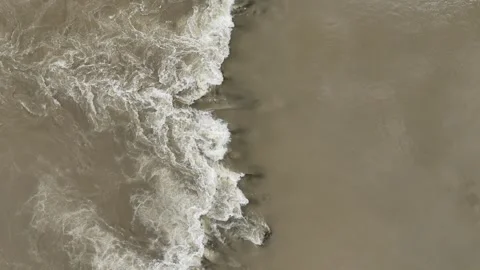 Aerial top-down view of turbulent muddy river water mixing Stock Footage 340362849