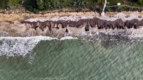 Aerial top-down view of turquoise sea waves crashing on sandy beach shore in 스톡 동영상 331044750
