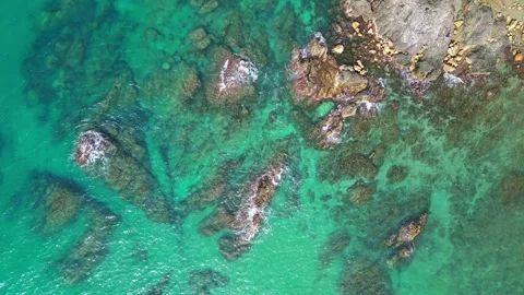 Aerial Top Down View of Turquoise Sea Waves and Underwater Rocks Stock Footage 335383598