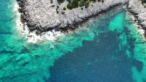 Aerial top down view of a turquoise coastal cove with clear water, rocky Stockbeeldmateriaal 336850208