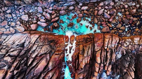 Aerial top-down view of turquoise water pool and colourful rock formations at Stock Footage 346418656