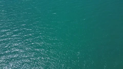 Aerial Top Down View of Turquoise Sea Water Surface with Sun Glare Stockbeeldmateriaal 347721912