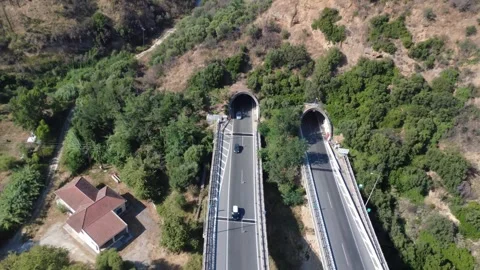 Aerial top-down view of twin highway tunnel portals in mountains Stock Footage 343961536