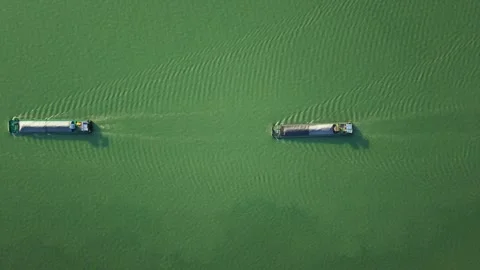 Aerial top down view of two barges navigate a river under serene conditions amid Stock Footage 311557909