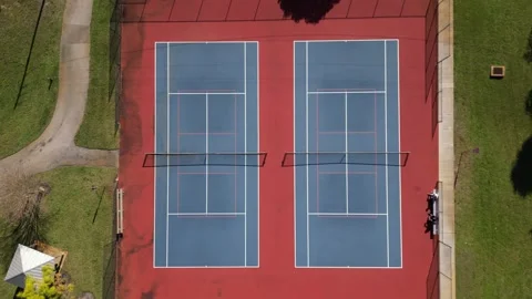 Aerial top-down view of two outdoor pickleball courts with blue surfaces Video stock 327672186