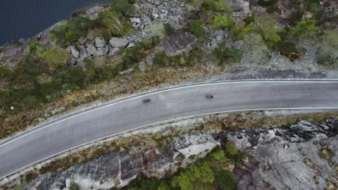 Aerial top down view of two professional cyclists riding fast on a curvy road in Video stock 335198507