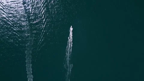 Aerial top down view of two motorboats speeding across deep blue ocean water Stock Footage 346232263