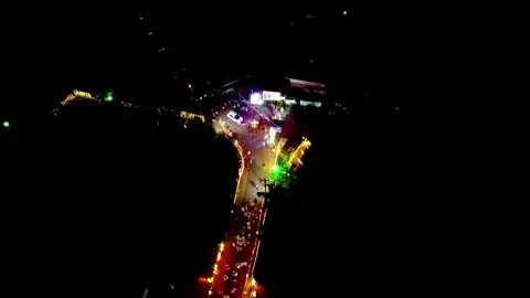 Aerial top-down view of a vibrant night festival or parade. Glowing floats and Stock-Footage 332568312