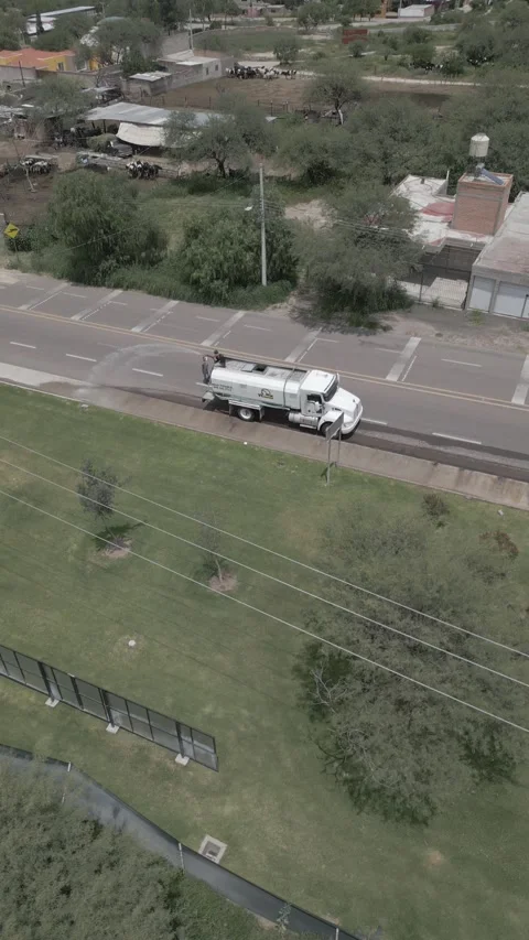 Aerial top down view of a water tanker truck spraying water to control dust Stock Footage 341549238