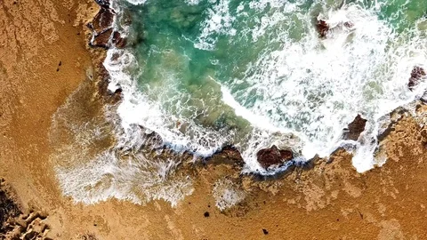 Aerial top down view of waves breaking on rocks Stock Footage 99829586