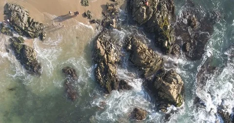Aerial Top Down View of Waves Crashing on Rocks Stock Footage 103740582