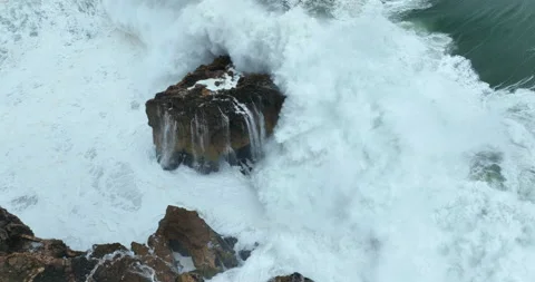 Aerial top down view of waves breaking on rocky cliff. Foamy waves crashing on Stock Footage 221830856