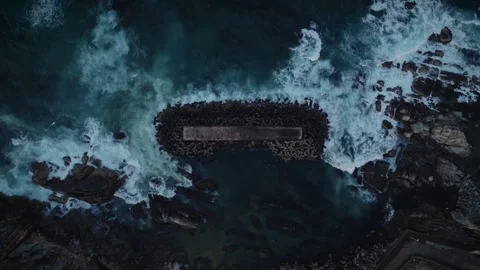 Aerial Top Down View of Waves Crashing on Tetrapod Breakwater Stock Footage 340263137