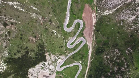 Aerial top down view of winding road in dolomites pordoi mountain pass Stock Footage 248003199