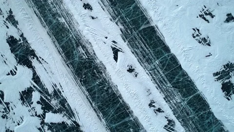 Aerial top down view on winter ice road on the frozen lake Baikal surface. Icy Vidéo 154120851