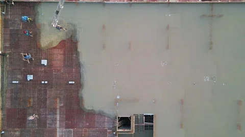 Aerial top-down view of workers pouring and spreading concrete over reinforced Stock Footage 300374607