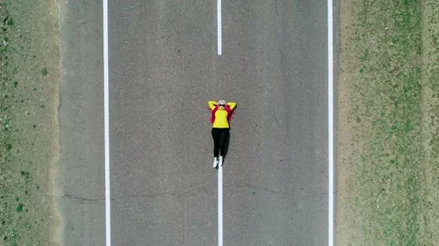 Aerial top down view of a young woman with pink hair braids and yellow jacket Video stock 187076504