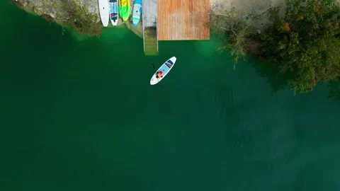 Aerial top down view of young woman paddleboarding on the lake in Cap Cana Stock Footage 306555818