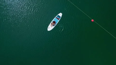 Aerial top down view of young woman paddleboarding on the lake in Cap Cana Stock Footage 306555844