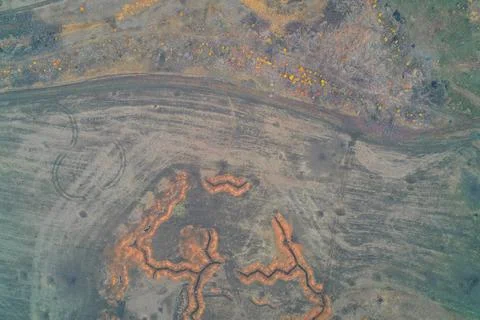 Aerial top down view of zigzag orange military trenches and vehicle tracks in Stock Photos