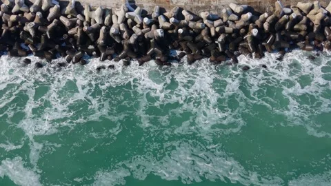 Aerial Top Down Waves Crashing Against Rocky Coastal Breakwater Stock Footage 328282299