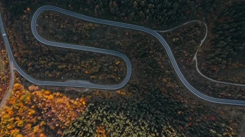 Aerial top down winding curving mountain road between hills, green and orange Stock Footage 197056606