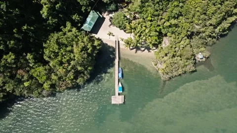 Aerial top downs hot of jetty with anchored boats with private beach at Stock Footage 235349784