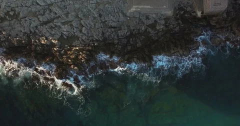 Aerial top shot Waves beating on the rocks Stock Footage 76982115