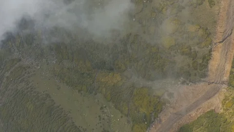 Aerial top vertical shot clouds float above green mountain Stock Footage 125706871